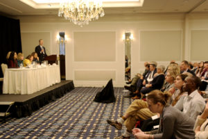 Economic workforce meeting panel and attendees in a large conference room