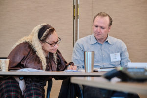 Photo of Julie Bunch and JJ Bartlett looking at a piece of paper on the table