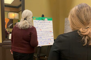 Attendees gather around giant Post-It notes at the Together in Recovery statewide convening