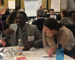 Attendees smiling around a table at the Together in Recovery Statewide Convening